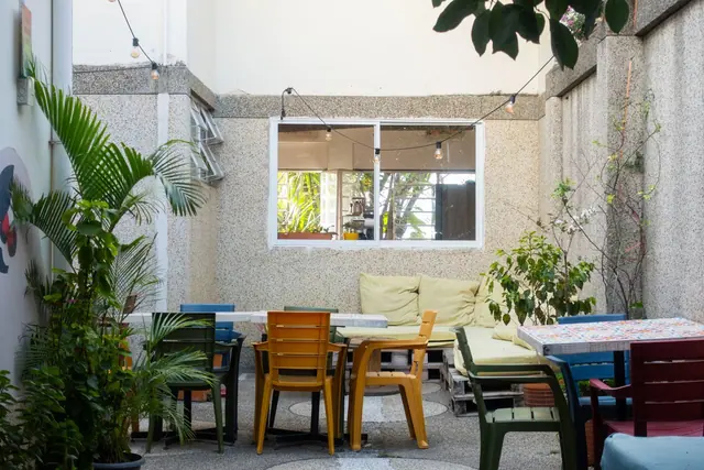 The open courtyard with mosaic tables, colourful chairs, lounge sofas and string lights.