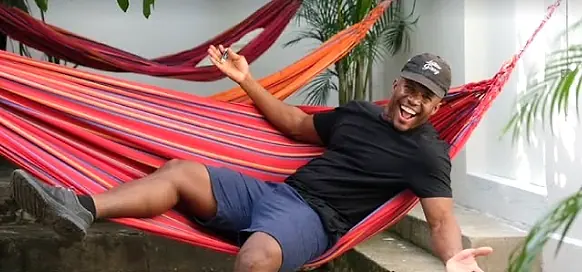 A guest laughing in a striped hammock.